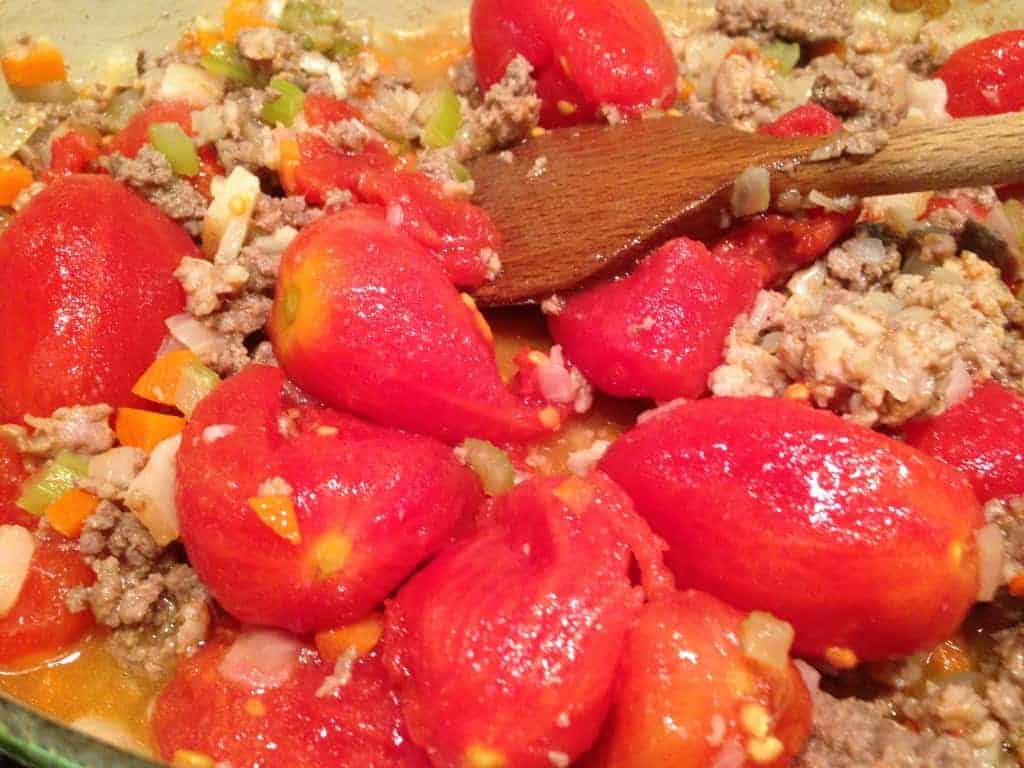 adding tomatoes to gluten-free bolognese sauce
