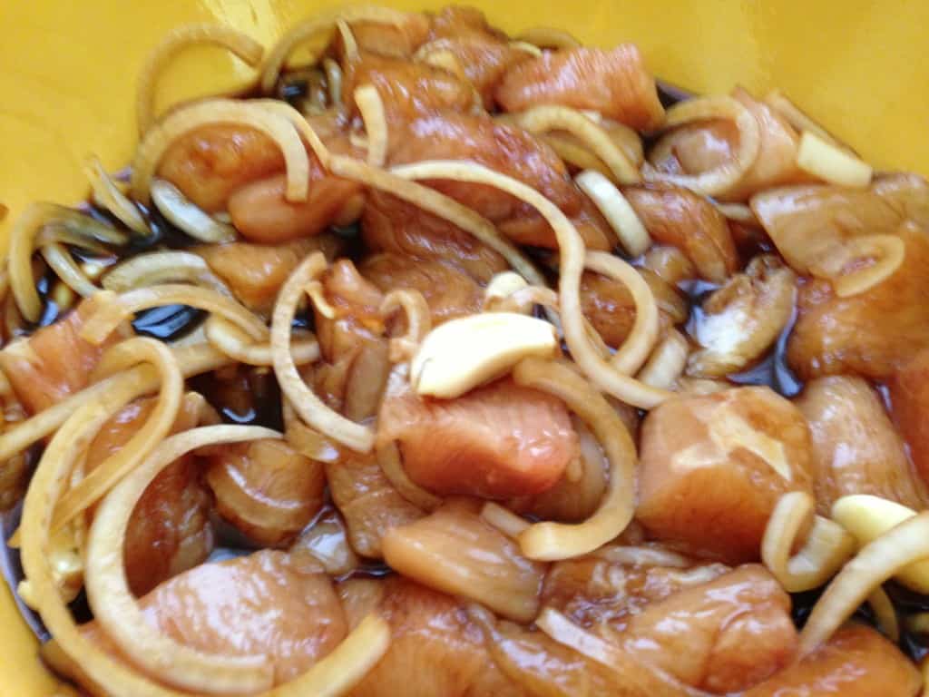 Marinating chicken in soy sauce, garlic, and onions.