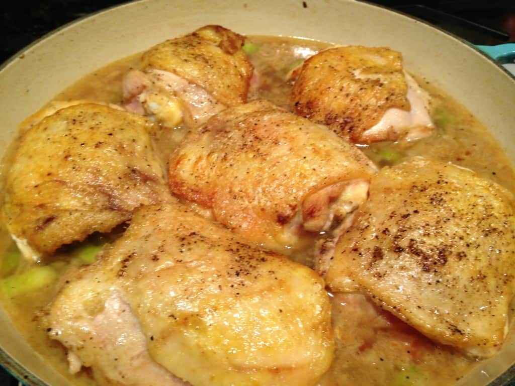 Browned chicken in braising sauce.