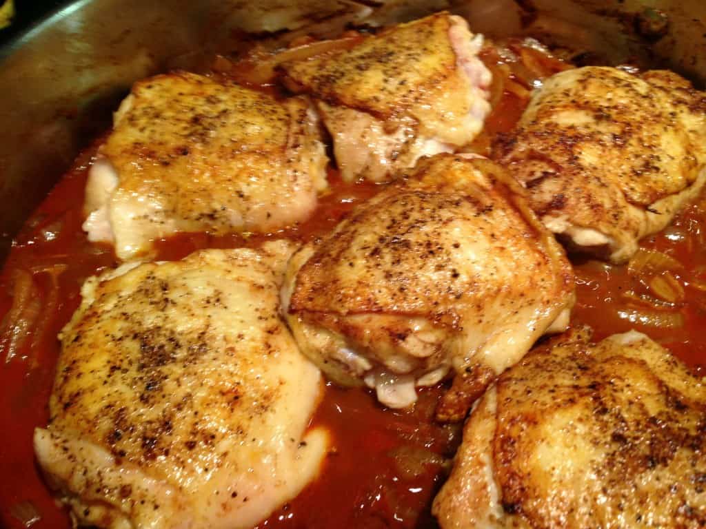 Chicken simmering in paprikash sauce.