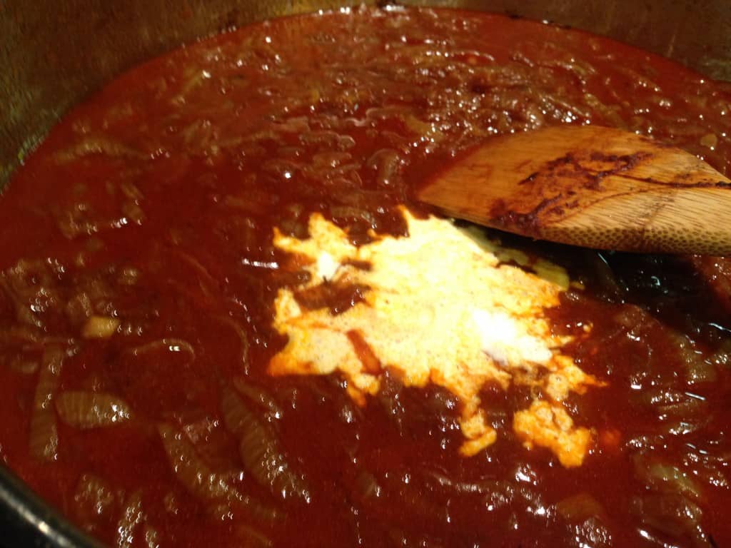 Adding sour cream to the paprikash sauce.