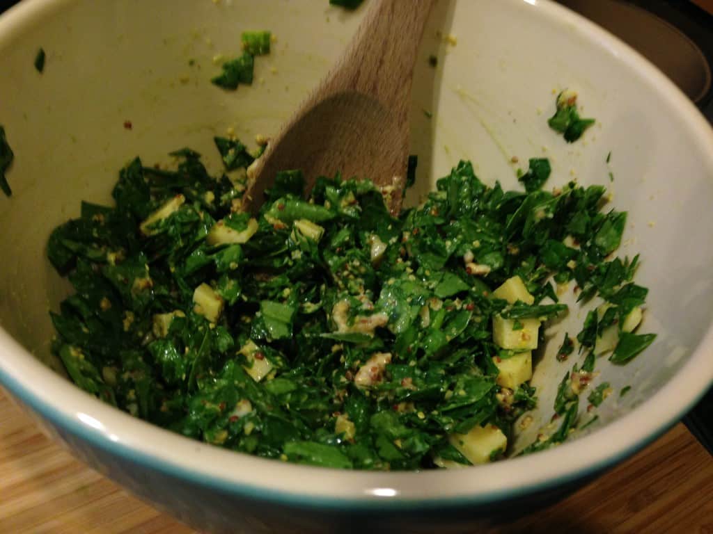 Mixing mustard into the spinach and gouda.